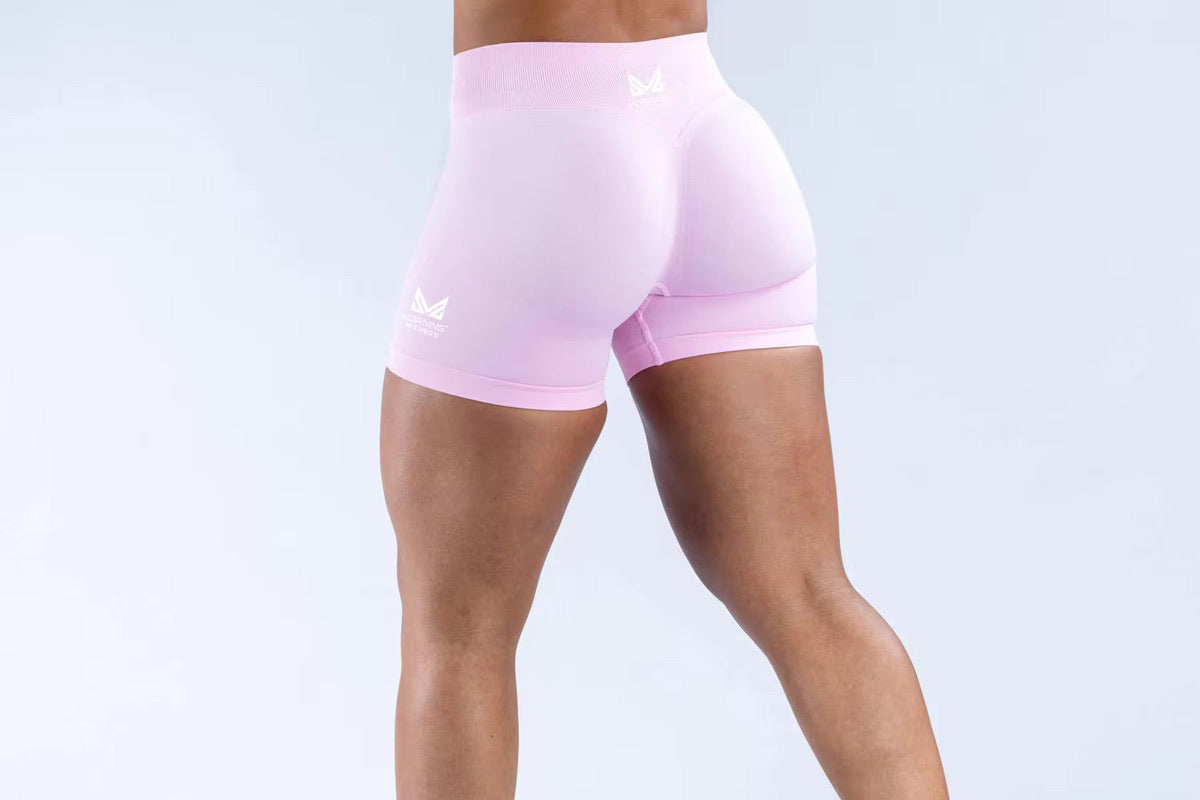Person wearing pink athletic shorts on a light gray background